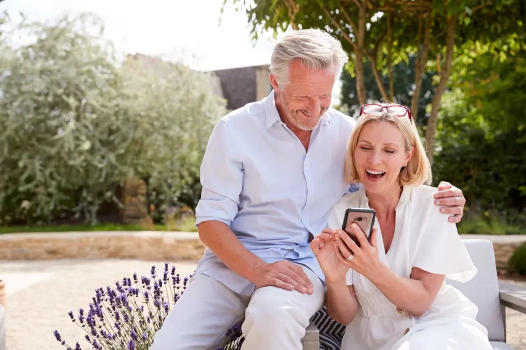 Happy couple outside looking at cell phone